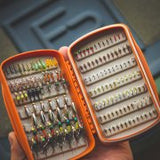 Waterprrof fly box for holding fishing flies for trout and salmon fishing in a bright urnt orange colour